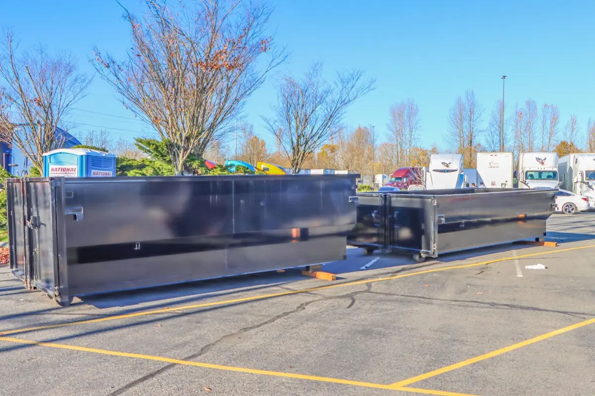 Professional dumpster rental service with roll-off container on residential driveway in Oscoda